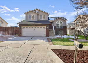 View of front facade with brick siding, a garage, concrete driveway, and a shingled roof