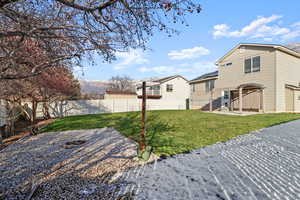 Fenced backyard with a patio, a mountain view, and a fire pit