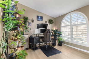 Office area with lofted ceiling and light wood-type flooring