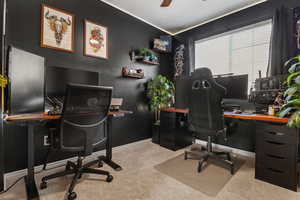 Home office with light colored carpet and a ceiling fan