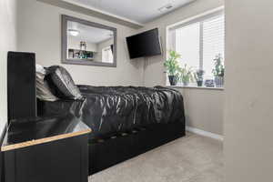 Bedroom with light colored carpet and baseboards