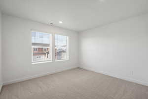 **DISCALIMER** Interior options may vary.Spare room featuring light colored carpet and recessed lighting