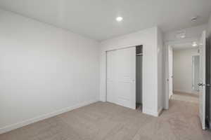 **DISCALIMER** Interior options may vary.Unfurnished bedroom featuring light colored carpet, a closet, and recessed lighting