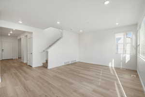 **DISCALIMER** Interior options may vary.Unfurnished living room featuring stairway, recessed lighting, and light wood-type flooring