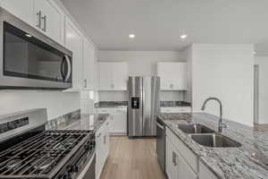 **DISCALIMER** Interior options may vary.Kitchen with stainless steel appliances, dark stone counters, white cabinetry, and recessed lighting