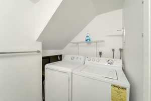 Laundry room with vaulted ceiling and washing machine and dryer