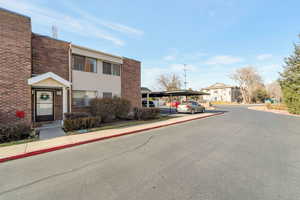 View of front facade with brick siding and covered parking