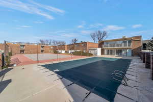View of swimming pool featuring a tennis court and a residential view