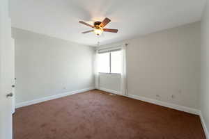 Unfurnished room featuring carpet floors and a ceiling fan