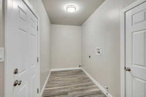 Laundry room featuring light wood-type flooring, washer hookup, and electric dryer hookup