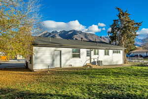 Rear view of property featuring a fenced backyard, a mountain view, and a patio area
