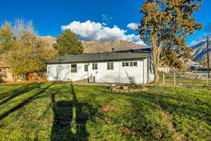 Rear view of house featuring a mountain view, a fenced backyard, a gate, and a patio