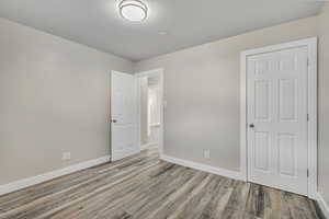 Unfurnished bedroom with baseboards and light wood-style floors