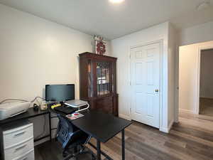 Home office with dark wood-style floors and baseboards