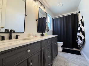 Bathroom with double vanity and shower / bath combo with shower curtain