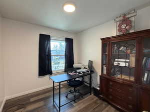 Office space featuring dark wood-style floors and baseboards
