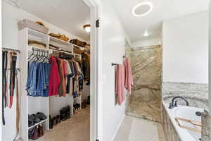 Full bath with a garden tub, a walk in closet, a walk in shower, and light tile patterned floors