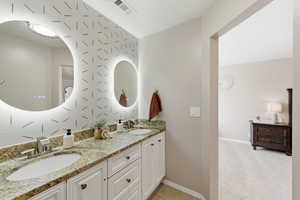 Bathroom featuring double vanity and light carpet