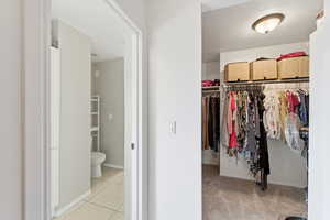 Walk in closet featuring light colored carpet