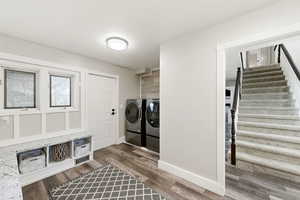 Washroom with wood finished floors and separate washer and dryer