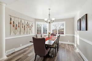 Dining room featuring hardwood / wood-style floors and a chandelier