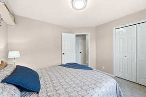 Carpeted bedroom featuring a closet and baseboards
