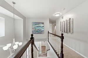 Hallway with a chandelier and an upstairs landing