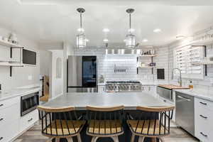 Kitchen featuring open shelves, white cabinets, appliances with stainless steel finishes, and recessed lighting