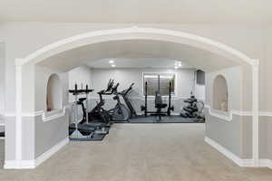 Exercise room with arched walkways and recessed lighting