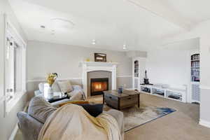 Living area featuring carpet and a tiled fireplace
