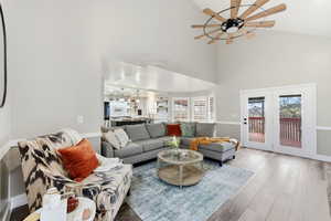 Living room with wood finished floors, high vaulted ceiling, recessed lighting, and a ceiling fan