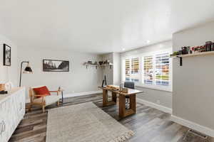 Office area with dark wood finished floors and recessed lighting