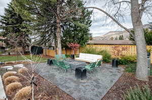 Fenced backyard with an outdoor living space with a fire pit and a patio area