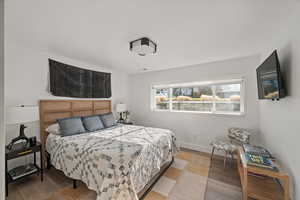 Bedroom featuring wood finished floors and baseboards