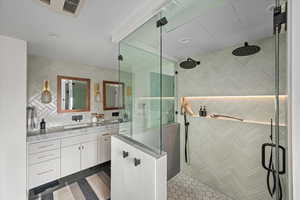 Primary bathroom featuring a custom double vanity, double steam shower and water closet