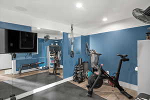 Exercise room with wood finished floors and recessed lighting