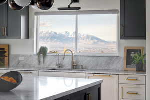 Kitchen with light stone counters, a mountain view, dark cabinets, and gray cabinets