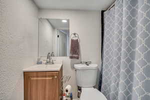 Bathroom featuring a shower with shower curtain and vanity