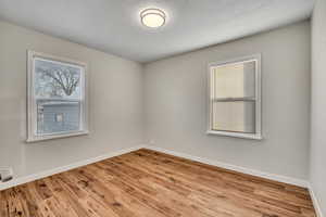 Spare room with light wood finished floors and a textured ceiling