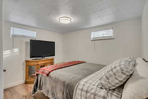 Bedroom with wood finished floors and baseboards