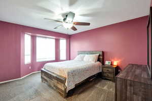 Bedroom featuring dark colored carpet and ceiling fan