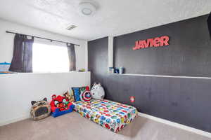 Bedroom with carpet flooring and a textured ceiling