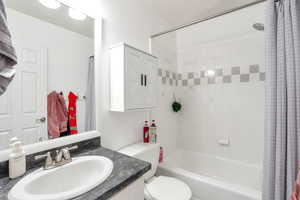 Bathroom featuring shower / bath combination with curtain and vanity