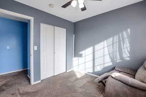 Living area featuring carpet and a ceiling fan