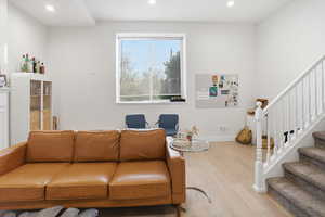 Living room featuring stairway, wood finished floors, and recessed lighting