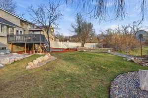 Fenced backyard featuring a deck and stairway