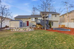 Rear view of house featuring stairway, a shed, a patio area, a deck, and stucco siding