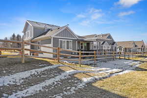 View of property exterior with board and batten siding, roof with shingles, and a residential view