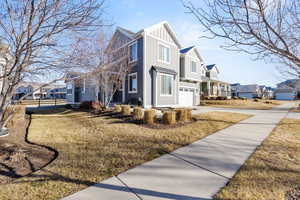View of home's exterior with board and batten siding, a residential view, driveway, and a garage
