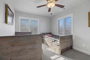 Unfurnished bedroom with carpet flooring, a ceiling fan, and multiple windows